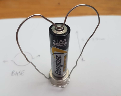 Image of finished heart motor with heart-shaped wire on battery.