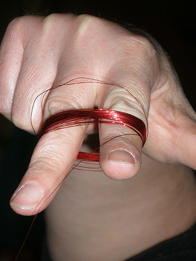  Hold the wire with 2 fingers as shown. To not allow wire to tangle or kink. If this happens, stop and untangle wire.
